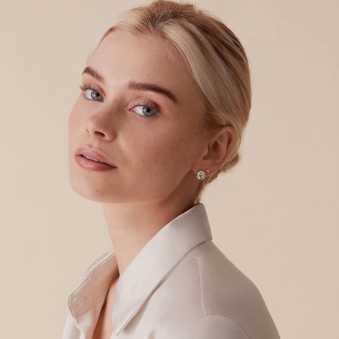 Model wearing elegant stud earrings with a floral design, paired with a classic white blouse for a sophisticated look