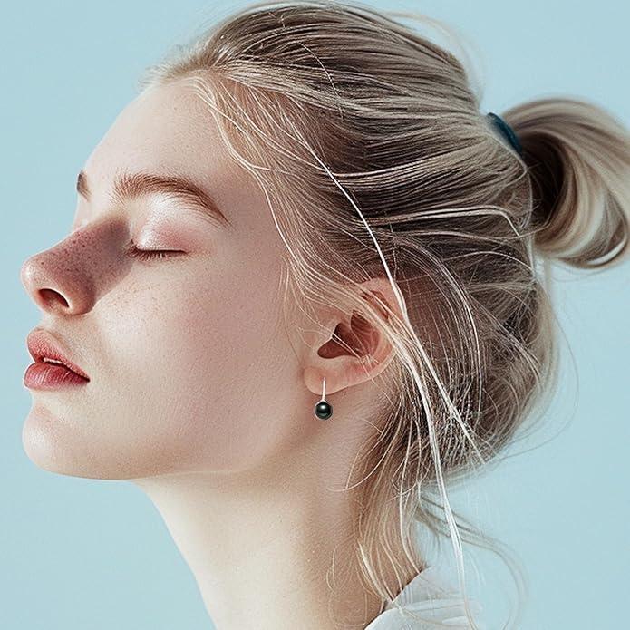 Model wearing delicate black pearl stud earrings with a minimalist design, paired with a sleek and elegant hairstyle.