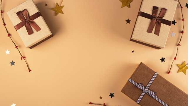 Gift boxes decorated with ribbons surrounded by star-shaped ornaments on a beige background, perfect for holiday or special occasion themes.