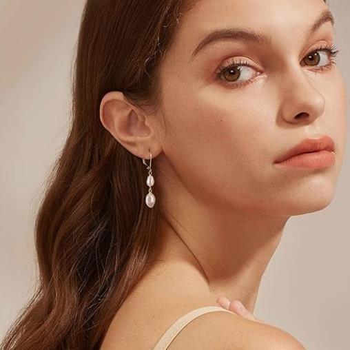 Model wearing elegant drop earrings with delicate pearl accents, showcasing a timeless and sophisticated jewelry design.