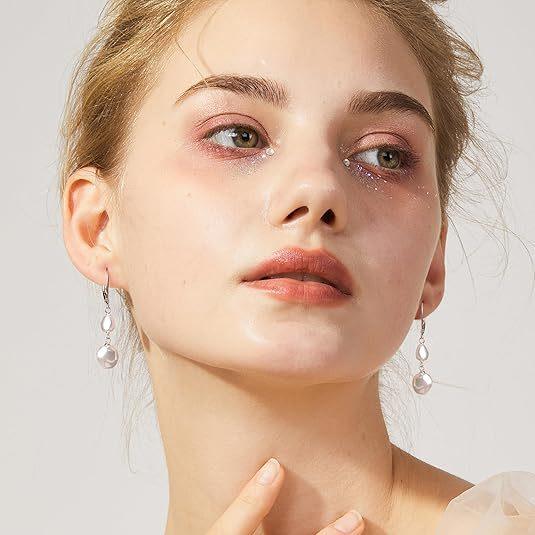 Model wearing elegant silver drop earrings with white pearls, adding a timeless and graceful touch to her look