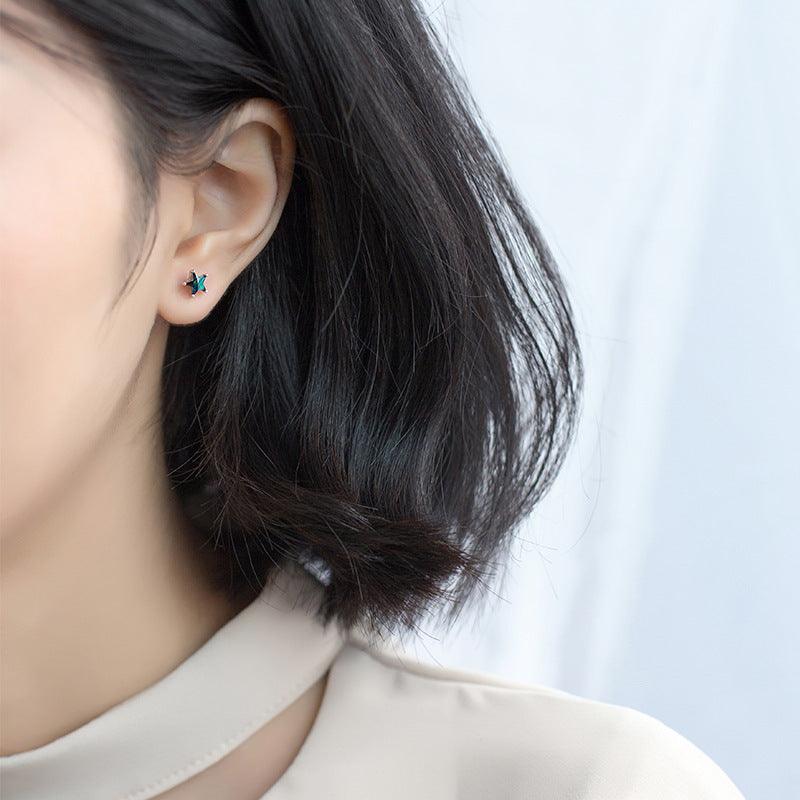 Model wearing star-shaped blue gemstone stud earrings, adding a subtle celestial charm to a minimalist look